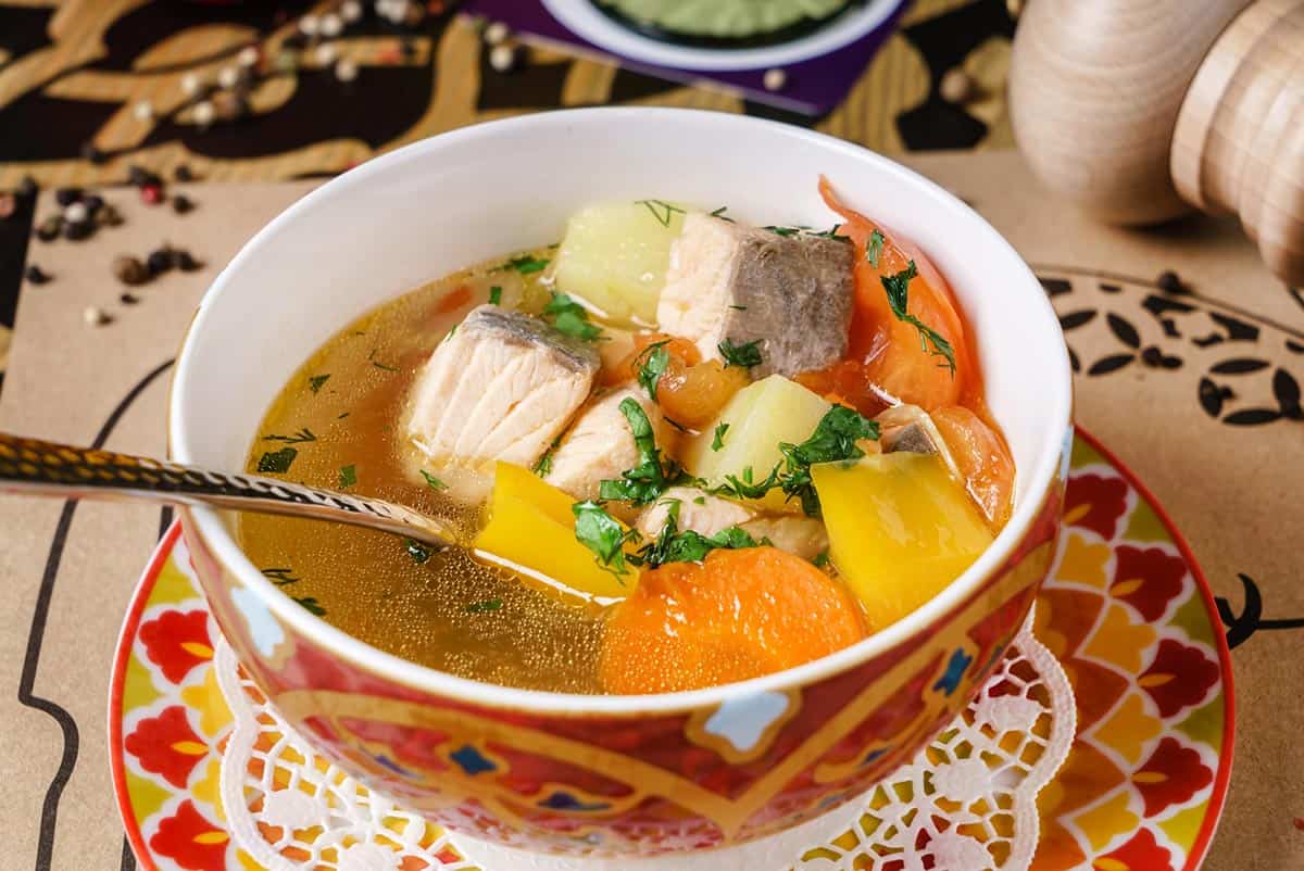 plato con sopa de pescado y sus verduras